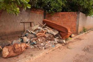 Planaltina, Goias, Brazil May 7, 2022 Trash and junk piled up on the side of the road near a house a common occurrences throughout Brazil, due to lack of garbage pick up photo