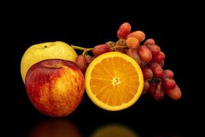 Orange, grapes, apple and pyrus pyriflora on a black background. photo