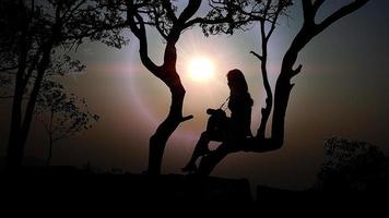 Women's silhouette at sunset on nature background. photo