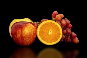 Orange, grapes, apple and pyrus pyriflora on a black background. photo