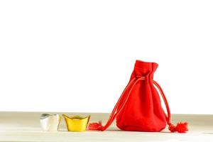 Red gift bag, gold and silver on a wooden floor photo