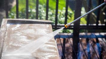 Cleaning plastic box on deck with pressure washer detail photo