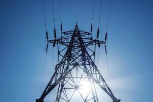 Electrical transmision high-voltage tower on blue sky background. photo