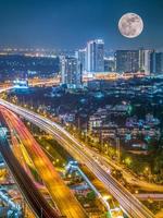 Surreal cityscape view under giant full bloody moon in Bangkok, Thailand