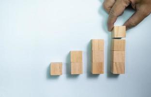 Top view hand place wooden blocks set to growth graph . Concept for money and success business. photo