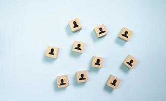 Top view wooden blocks with people icon on blue background. Concept for company and human resorce manangement. photo