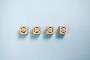Top view wooden blocks with smiley face graphic. Concept for rating and customer satisfaction. photo