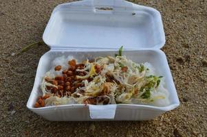 bubur ayam jakarta, bought on the roadside. using a place of styrofoam and with a sand background photo