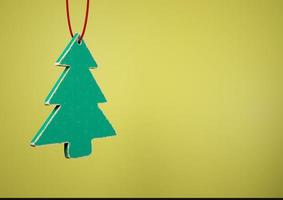 Old toy wooden Christmas tree on yellow background photo