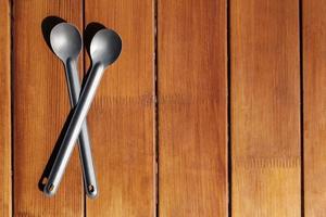 Titanium camp spoons on a wooden table photo