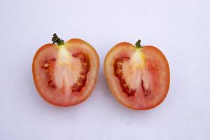 Dos rebanadas de tomate rojo maduro sobre fondo aislado foto