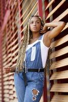 Stylish black woman with Afro braids in city photo