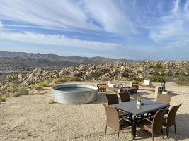 Back yard patio area with a pool and table photo