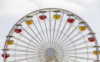 carros amarillos y rojos en una gran noria blanca foto