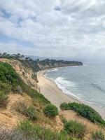 View from on top of cliffs on a sandy beach photo