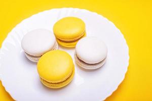 Sweet and bright banana and currant macarons on a white plate. French dessert. photo