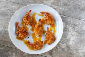 fried coconut shrimp with drizzled with sweet sauce flat lay photo