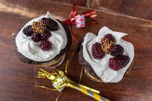 chocolate cake in a fancy glass mug with whip cream and fresh blackberries photo