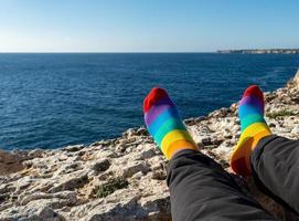 socks with the colors of the flag of the lgtb community. relaxed in front of the sea. Pride concept with copy space photo