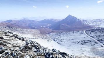 Paisaje de representación 3d de montañas cubiertas de nieve invernal y rocas enormes, cielos despejados. foto