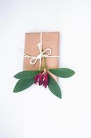 Gift box in craft packaging on a light white background photo