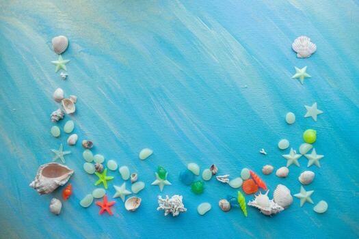Seashells summer background. Many different seashells, starfish on a background of turquoise paint strokes. Place for text with border at the bottom edge. photo