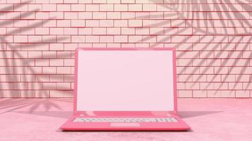 Pink laptop with decoration minimal. Shadow from tree and window on brick wall. Mock-up computer. photo