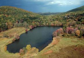 Lake nestled between a mountain in fall photo