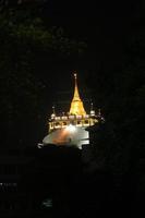 Golden color pagoda Thai style in Wat Sraket or Phu Khao Thong at night, Bangkok,Thailand. photo