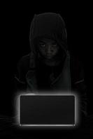 Hacker boy are hacking through the laptop on a black background. photo