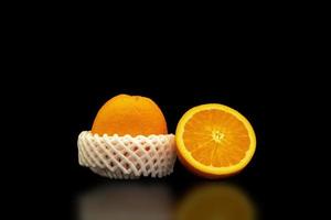 una naranja fresca y saludable sobre un fondo negro. foto