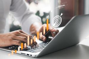 Businessman analyzing company's financial balance sheet working with digital augmented reality graphics. Businessman calculates financial data for long-term investment. photo