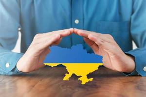 I support the Ukrainian Ukrainian flag with prayers, end the war, make peace for Ukraine. The concept of the Ukrainian and Russian military crises. photo