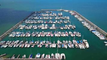 Marine port for yacht, motorboat, sailboat parking service and moorings for luxury and wealthy millionaire in aerial view with many ships anchoring along the dock bay video