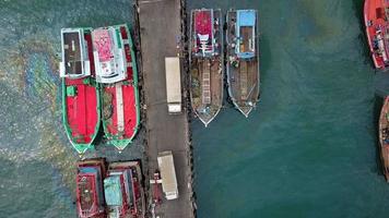 luchtfoto van vissersdok waar veel vissersschepen voor anker liggen voor het transport van zeevruchten en benodigdheden in het binnenland video