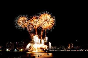 Many flashing fireworks with night cityscape background celebrate New Year. photo