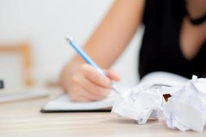 Closeup hand asian woman writer thinking idea and writing on notebook or diary with happy on desk office, lifestyle of asia girl is success, female planning working, education and business concept. photo