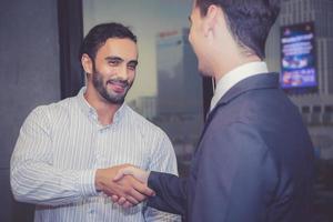 dos hombres de negocios estrechando la mano con éxito, acuerdo de discusión con apretón de manos después de reunirse en equipo, concepto de comunicación. foto