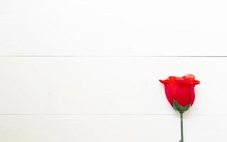 regalo presente con flor de rosa roja sobre mesa de madera, 14 de febrero del día del amor con espacio de copia romántica, concepto de vacaciones de San Valentín, vista superior. foto