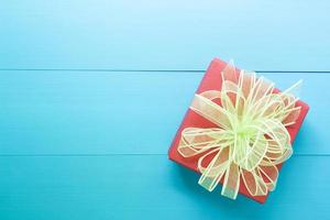 Holiday of Gift box with bow ribbon on wooden blue table, present of romantic day on wood, Valentine festive concept, top view, vintage retro tone. photo