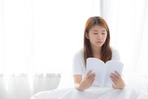 Beautiful of portrait young asian woman relax sitting reading book on bedroom at home, girl study literature, education and llifestyle concept. photo