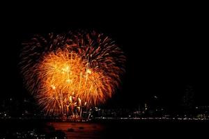 Many flashing fireworks with night cityscape background celebrate New Year. photo