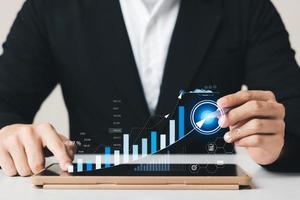 Businessman analyzing company's financial balance sheet working with digital augmented reality graphics. Businessman calculates financial data for long-term investment. photo