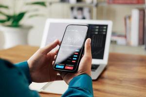 Businessmen work with stock market investments using smartphone to analyze trading data. smartphone with stock exchange graph on screen. Financial stock market. photo