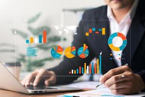 Businessman analyzing company's financial balance sheet working with digital augmented reality graphics. Businessman calculates financial data for long-term investment. photo