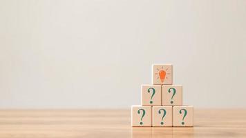 Creative concept. Think different, wooden cube with question mark and light bulb sign. photo