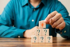Creative concept. Think different, wooden cube with question mark and light bulb sign. photo
