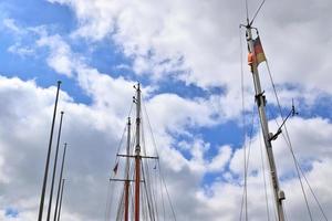 Sailing ship mast against the blue sky on some sailing boats with rigging details. photo