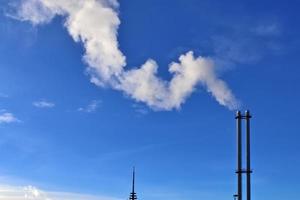 Industry pollution from factory smoestacks in a deep blue sky photo