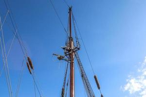 Sailing ship mast against the blue sky on some sailing boats with rigging details. photo